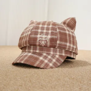 Vista detallada de gorra octogonal de cuadros con orejas de gato bordadas, estilo invernal