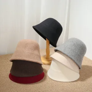 Close-up details of multiple wool bucket hats in various colors, soft fabric texture.