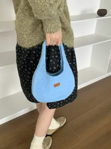 Detail view of the stylish light blue knitted shoulder bag, perfect autumn winter accessory.