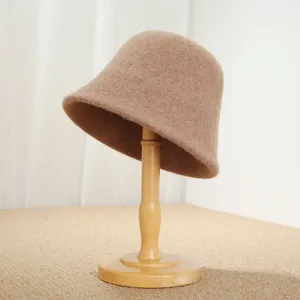 Detailed view of the vintage camel wool bucket hat displayed on a wooden stand, showing texture.
