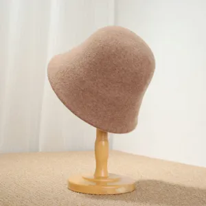 Detail view of a classic French vintage wool bucket hat, winter warm fisherman hat on a wooden stand.