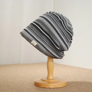 Close-up detail of the retro black, white, and gray striped knit slouchy beanie hat texture.