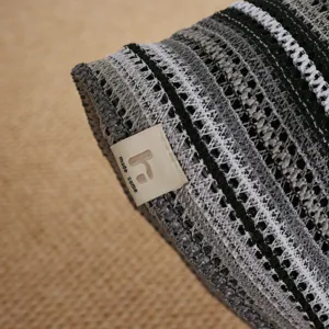 Close-up detail shot of the black and white striped knit beanie showing fabric texture.