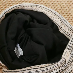 Close-up detail of retro striped knit slouchy hat showing interior fabric and brim texture.