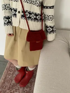 Rote geflochtene Handytasche Detail mit Stricktextur und Rüschen Design für den Winter.