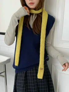 Detailaufnahme eines stilvollen gelben Strickschals mit Weste für die Herbst- und Wintersaison.