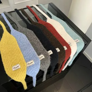 Detailaufnahme bunter Strick-Schals mit weicher Textur und aufgenähtem Markenetikett.