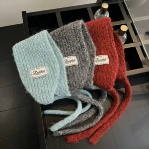 Strickmütze Ohrenklappen Detailansicht, gemütliche Wintermütze mit langen Bändern in Farben.
