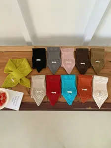 Detailansicht des hohlen Strick-Kreuzhalswärmers in verschiedenen Farben, kuscheliger Schal.