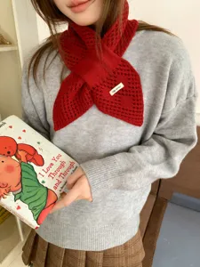 Nahaufnahme des roten Strick-Kreuzschals mit Lochmuster und gemütlichem Winterstil-Design.