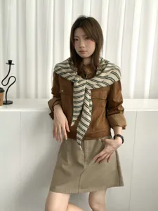 Detailed view of the stylish striped knitted triangular shawl worn on shoulders, cozy style.