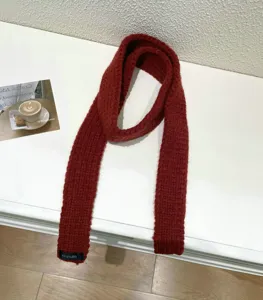Dark red knitted scarf detailed view, slim baguette style winter neck warmer for women.