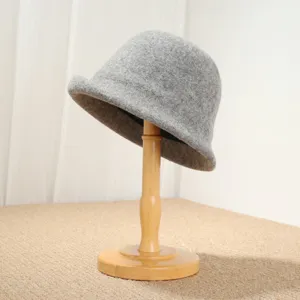 Close-up detail of the grey wool felt cloche hat, showcasing the exquisite rolled brim texture.