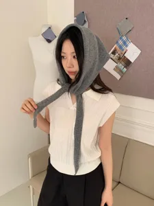 Vista detallada de la elegante capucha triangular de punto gris y top polo sin mangas para mujer.