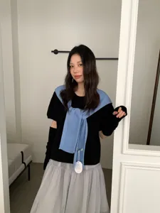 Stijlvolle blauwe gebreide sjaal shawl gecombineerd met zwarte top en grijze tulen rok voor herfst.