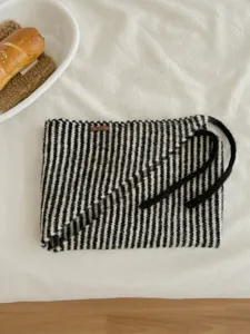 Primo piano della sciarpa triangolare a righe lavorata a maglia con morbidi lacci comodi.