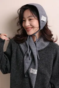 Scatto di dettaglio cuffia in maglia grigia e sciarpa donna, abbigliamento caldo moda invernale.