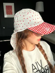 Gros plan d'une élégante casquette foulard blanche avec étoiles rouges et visière à carreaux.