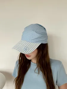 Vue détaillée d'une casquette bleu clair à pois avec visière à carreaux pour l'été.