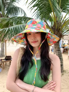 Vue détaillée du chapeau bob à imprimé de dessins animés colorés avec lanière sur la plage.