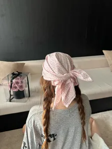 Gros plan detaille du foulard floral dans un cadre lifestyle, mettant en valeur le style ete.