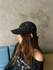 Vista de detalle de la gorra bandana negra con estrellas usada por la modelo.