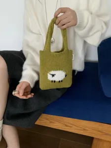 Vista detalle bolso de oveja tejido de punto, hermoso bolso de mano verde de cerca.