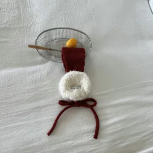 Nahaufnahme von flauschigen Plüsch-Ohrwärmern im Winter mit weicher Textur und süßer Schleife.