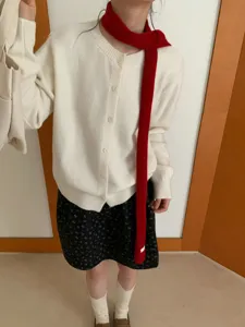 Detailansicht eines stilvollen roten Strickschals, getragen vom Model, gemütlicher warmer Kragen.