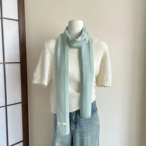 Hellgrüner Strickschal Detailansicht, weiche Wolltextur, elegantes einfarbiges Accessoire.