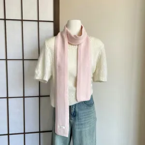 Rosa Strickwollschal Detailaufnahme, kuscheliges Winterhalstuch, weiche Textur Produktpräsentation.