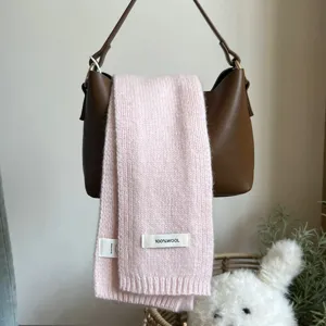 Rosa Strickschal Detailansicht, weiches Wollmaterial mit Etikett, kuscheliger warmer Schal.