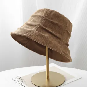Corduroy bucket hat detail showing retro pleated texture and rich brown tone for autumn wear.