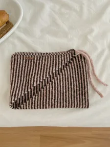 Dettaglio sciarpa triangolare a maglia a righe con coulisse, scaldacollo invernale morbido e caldo.