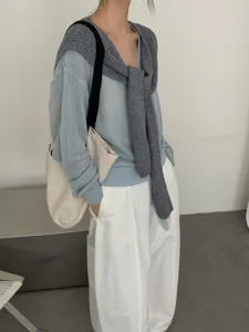 Koreaanse vintage gebreide trui met gedrapeerde sjaal en casual witte broek outfit.