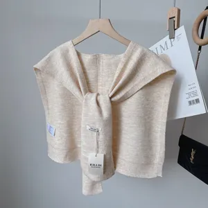 Knitted wool blend shoulder shawl detail, beige cape wrap with front knot and branded tag.