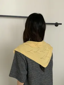 Detailed view of women's hollow out knitted triangular scarf yellow wool winter warm shawl
