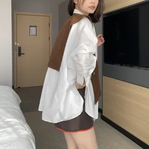 Knit shawl detail view, showing layered white shirt and brown skirt outfit style for indoor wear.
