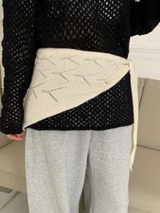 Knitted hollow triangle scarf waist wrap accessory, chic textured detail shot for women.