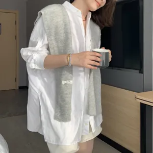 Detailed view of the layered knit shawl and white shirt outfit, showcasing casual daily wear.