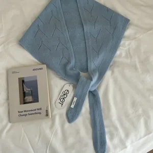 Light blue hollow knitted triangular scarf for women, elegant warm winter wool neck wrap.