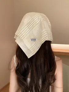 Primer plano detallado de un gorro de panueluelo a cuadros amarillos con etiqueta tejida, espalda.