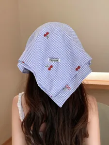 Pañuelo de cuadros azul y blanco con delicados bordados de cerezas rojas y etiqueta de marca.