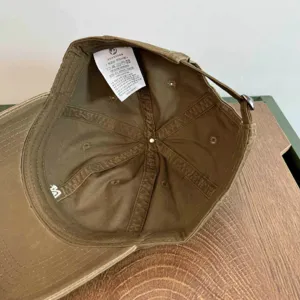 Detalles del interior de la gorra de algodón, mostrando etiqueta y costuras finas.