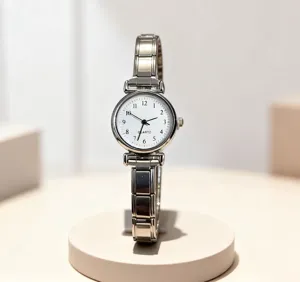 Detailaufnahme einer Edelstahl-Quarzuhr mit klarem weißem Zifferblatt und elastischem Metallarmband.