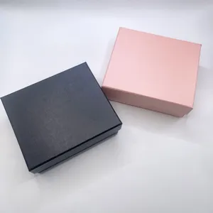 Detailed view of textured paper watch and jewelry gift boxes in black and rose gold colors.