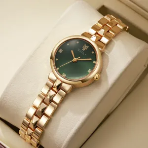 Detailaufnahme einer Damenuhr mit goldenem Metallarmband und grünem Zifferblatt. Elegant.