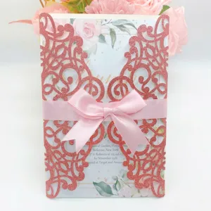 Elegant pink laser-cut wedding invitation card featuring floral design and satin bow.