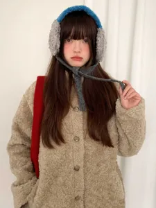 Detail view of cozy plush fleece earmuffs with warm ties in blue, perfect for winter.
