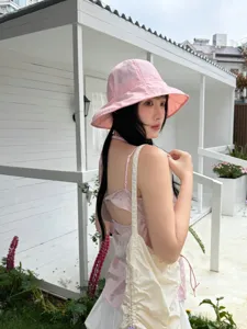 Detail of the pink bucket hat in outdoor scene, showing light summer fabric and cozy style.